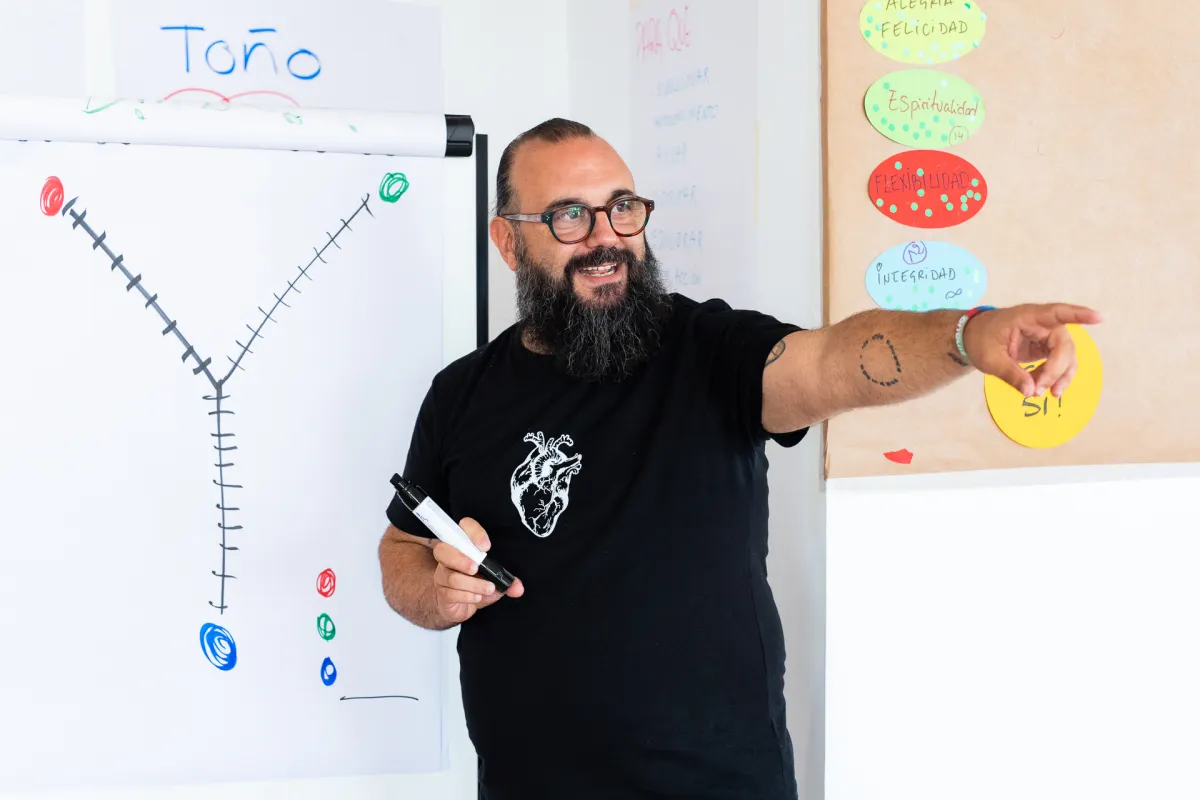Toño Galán, durante una formación, señalando un panel con valores escritos en cartulinas de colores